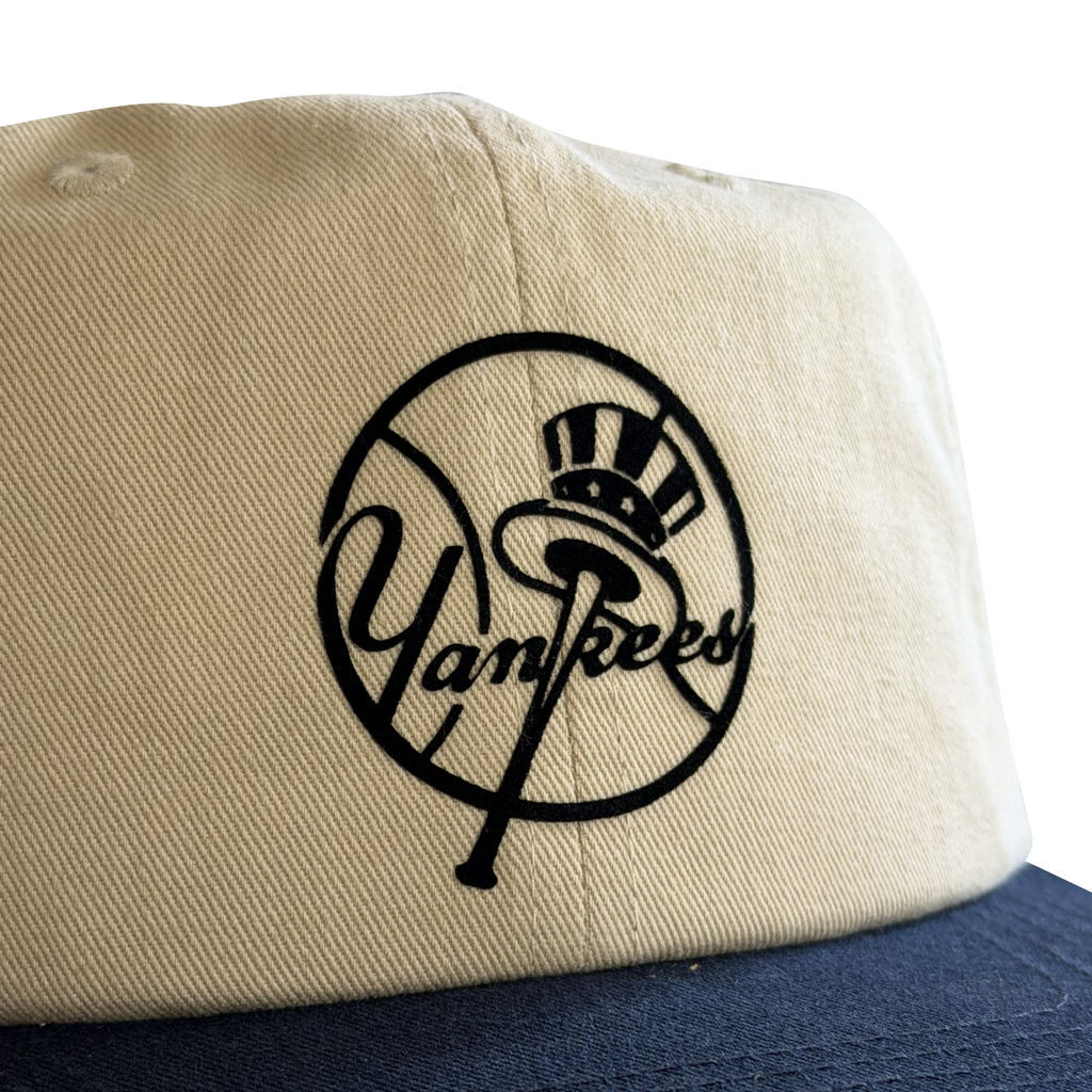 Vintage New York Yankees Bat and Hat Hat | 6 Panel Snapback Hat in cream with black Yankees bat and hat circle logo, close up from My Store