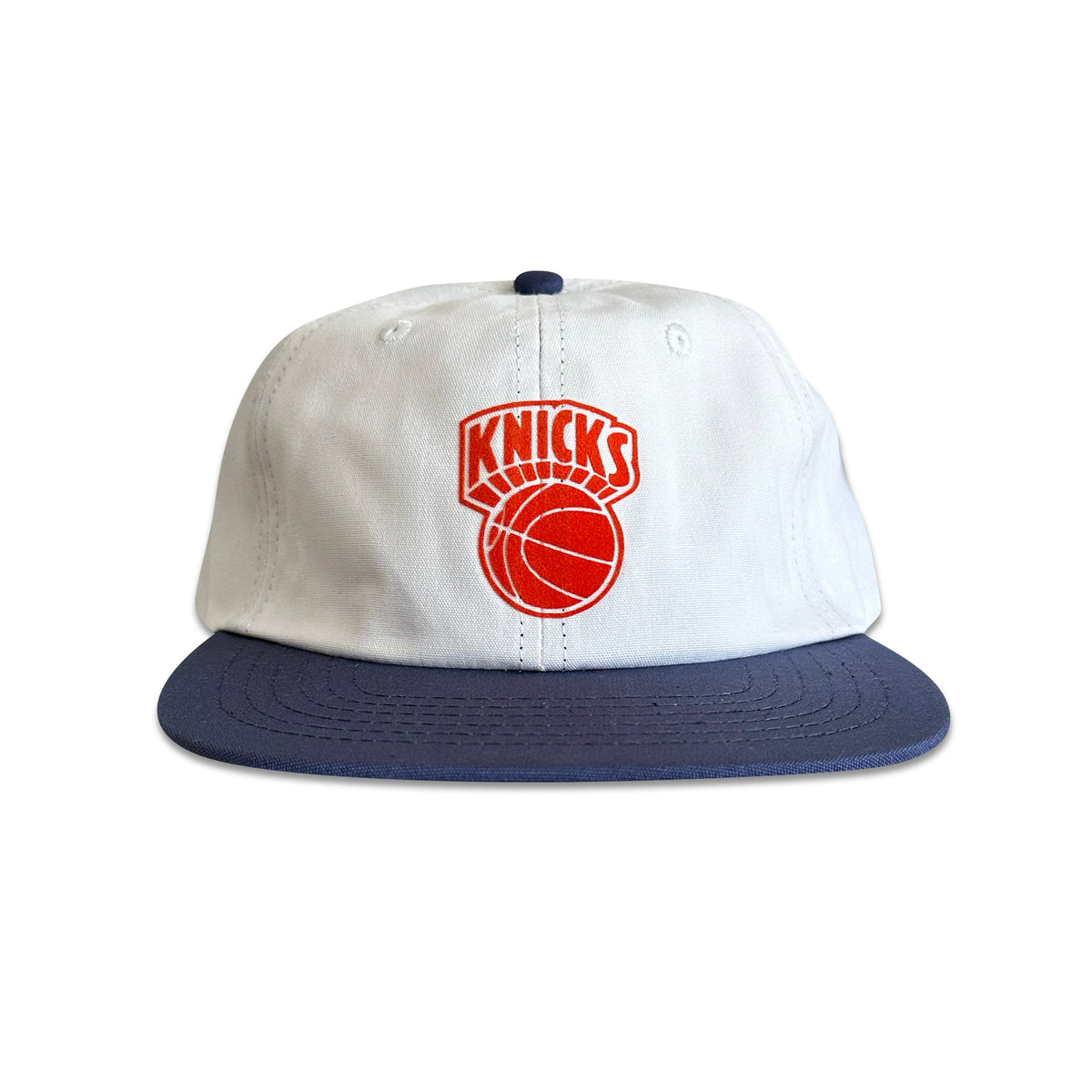 A white and navy blue New York Knicks baseball cap with a red logo on the front.